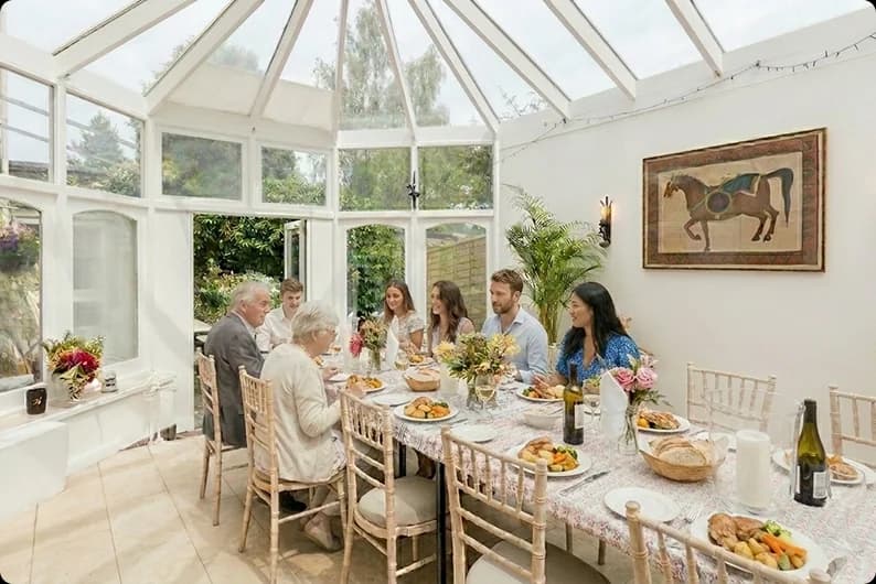 Guests sharing lunch around a table in a bright dining room