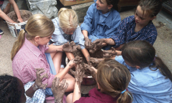 An overhead shot of a group of children working with clay and getting messy in the process
